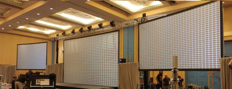 This is a picture of a corporate AV setup in Orlando Fl with the technician aligning the projectors to the screens during an AV setup by MAC Production Group