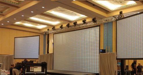 This is a picture of a corporate AV setup in Orlando Fl with the technician aligning the projectors to the screens during an AV setup by MAC Production Group